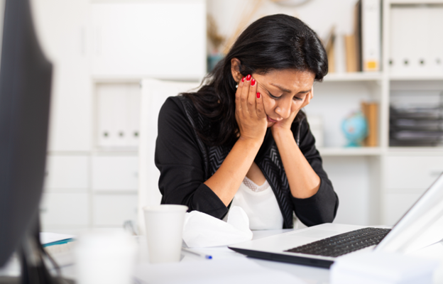 woman at desk showing signs of anxiety