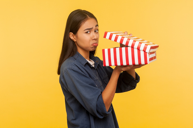 Woman with sad face opening present