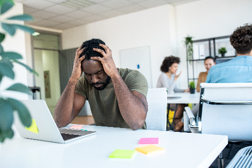 Man holding head looking stressed and burnout.