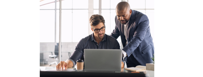 Manager with employee working on computer
