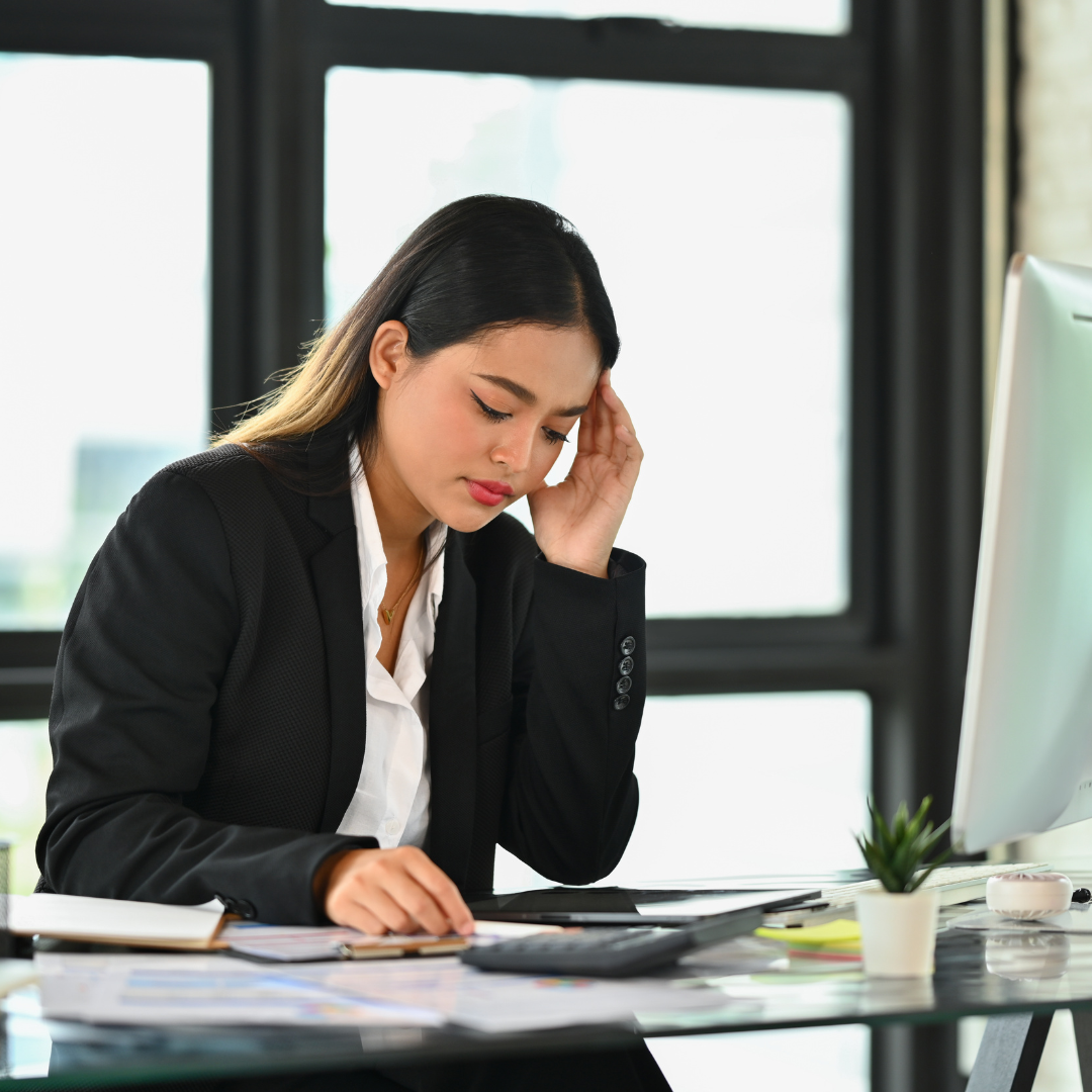 woman holding her head while at work