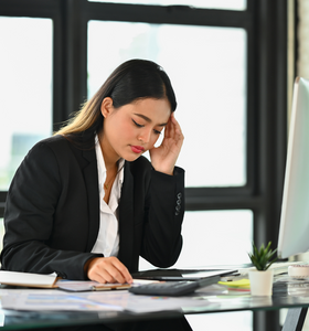 woman holding her head while at work