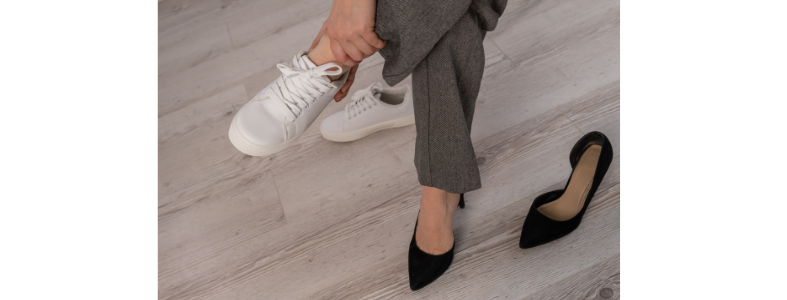 Woman changing from heels to sneakers