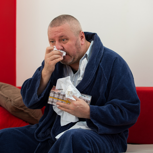 Man with a cold blowing his nose