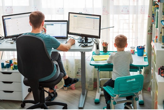 Father and son working at desks side by side