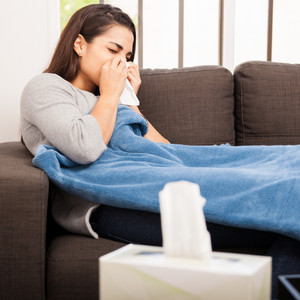 Woman with a cold blowing her nose