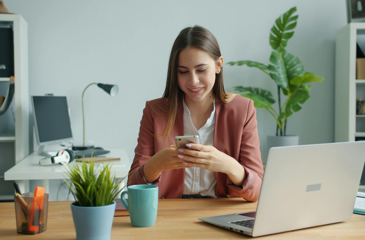 young woman looking at phone in office