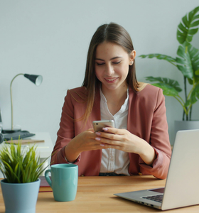 young woman looking at phone in office